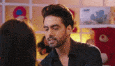 a man with a beard is looking at a woman .
