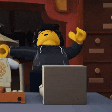 a lego figure is sitting on a table with his arm outstretched
