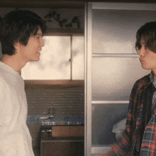 a man in a plaid shirt talks to another man