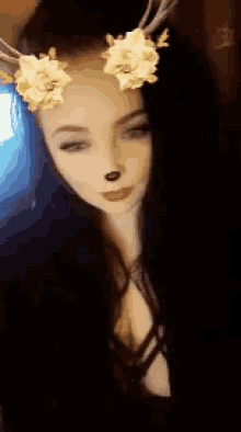 a woman wearing a deer headband with yellow flowers on it