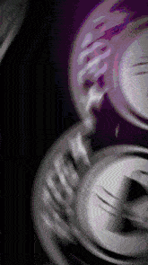 a close up of a purple and silver object with a black background