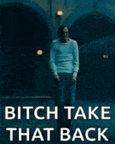 a man in a white shirt is standing in a dark room with the words `` bitch take that back '' .