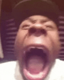 a close up of a person yawning with their mouth open .