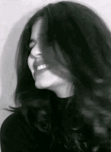 a black and white photo of a woman with long hair .