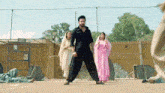 a man in a black suit is standing in front of a group of people