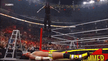 a wrestler is jumping over another wrestler who is laying on the ground