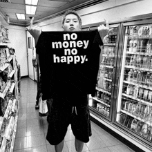 a man in a store holds up a shirt that says no money no happy