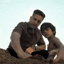 a man and a boy are playing in the sand and the watermark toms 2006 is on the bottom right