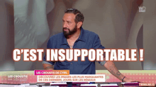 a man with a beard stands in front of a screen that says c'est insupportable