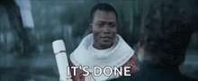 a man is holding a scroll and talking to another man while another man says `` it 's done '' .