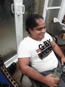 a man wearing a white t-shirt with the word cb on it