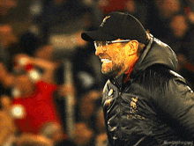 a man wearing a black hat and a jacket that says rivals on it