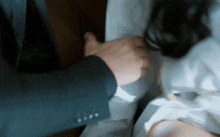 a man in a suit and tie is touching a woman 's arm .