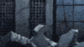 a blurry picture of a person standing in front of a building with a fence .