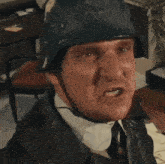 a man wearing a helmet and a leather jacket looks angry