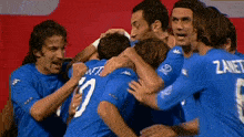 a group of soccer players are hugging each other and one of them has the number 10 on his back