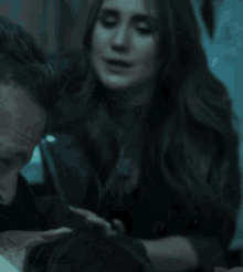 a man and a woman in a dark room with a heart in the corner