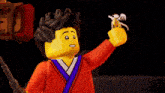a lego figure is holding a piece of paper and smiling