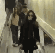 a group of people are walking down a hallway with one wearing sunglasses