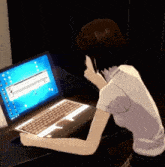 a girl is sitting in front of a laptop with a screen that says ' windows ' on it