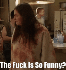 a woman standing in a kitchen with the words " the fuck is so funny " on the bottom