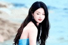 a woman in a blue dress stands in front of a blue background that says columbia