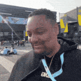 a man wearing a black hoodie with a blue lanyard that says the on it