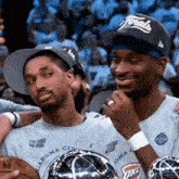 two men wearing oklahoma city shirts are holding a basketball