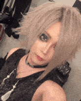 a woman with a choker around her neck takes a picture of herself
