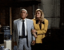 a man in a suit and tie is standing next to a woman