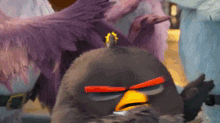an angry bird from the angry birds movie with a purple bird behind it