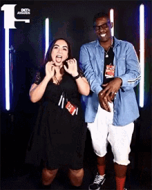 a man and a woman are posing for a photo in front of a bet awards logo