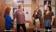 a group of people are standing in a room with a nbc logo on the bottom right