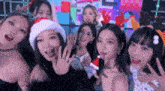 a group of women are posing for a picture together while wearing santa hats .