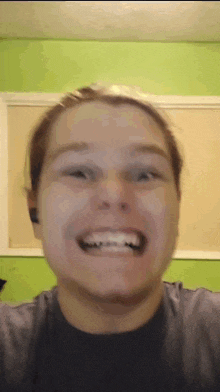a woman wearing ear buds is smiling and making a funny face