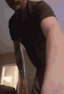 a man with tattoos on his arms is standing in a room