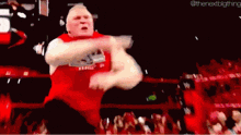 a man in a red shirt is dancing in front of a crowd of people .