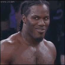 a shirtless man is smiling and looking at the camera