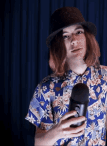 a man in a hat is holding a microphone