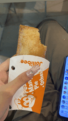 a person is holding a jollibee pie in their hand