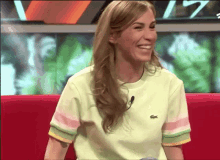 a woman wearing a green shirt with a crocodile on it