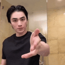 a man in a black shirt is pointing his finger at the camera