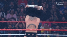 a man in a wrestling ring with the peacock logo on the screen