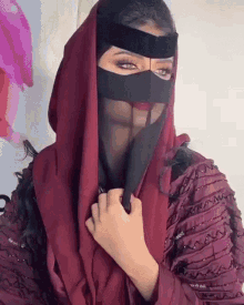 a woman wearing a red scarf and a black mask