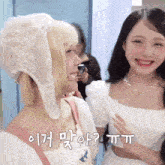 two girls are standing next to each other and one of them is wearing a white dress