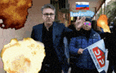 a man in a suit is holding a flag that says pdp