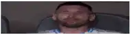 a man is crying while sitting in a chair covering his face with his hands .