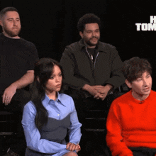 a group of people are sitting in front of a sign that says tonight on it