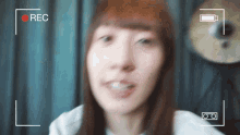 a woman 's face is being recorded by a camera with a red rec button