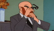 a bald man with a beard is wearing glasses and a suit